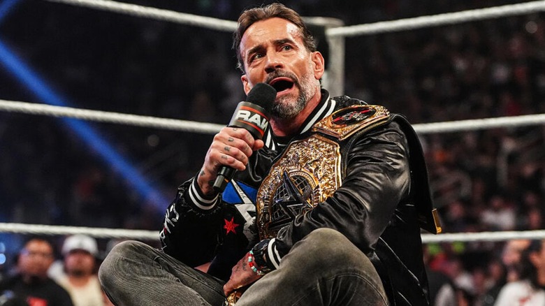 CM Punk sitting cross-legged in the middle of the ring with the World Heavyweight Championship, cutting what WWE has described as another 