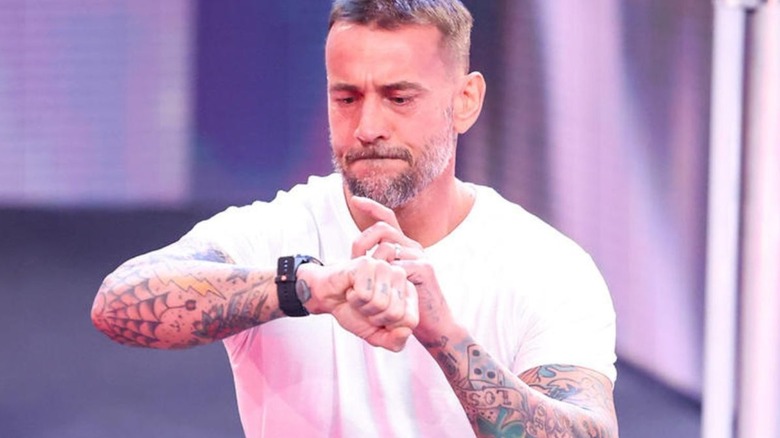 CM Punk returns to WWE at Survivor Series: War Games and poses on the stage.