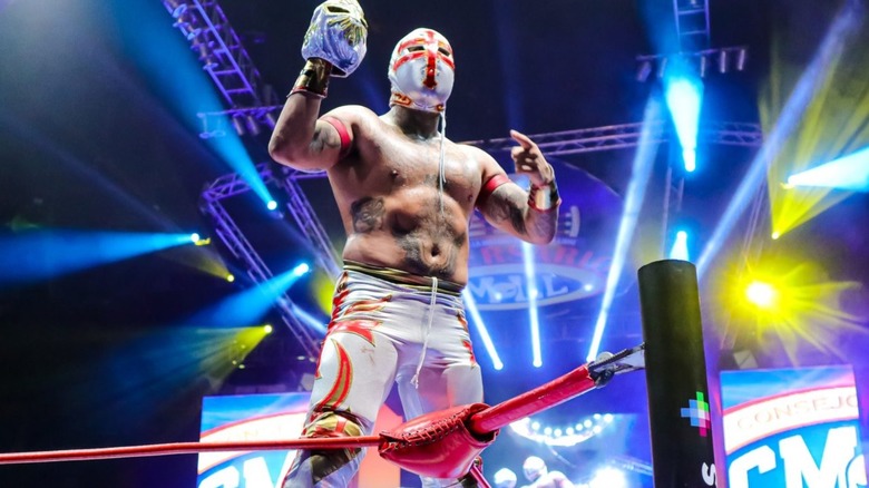 Templario, holding up the mask of Mistico