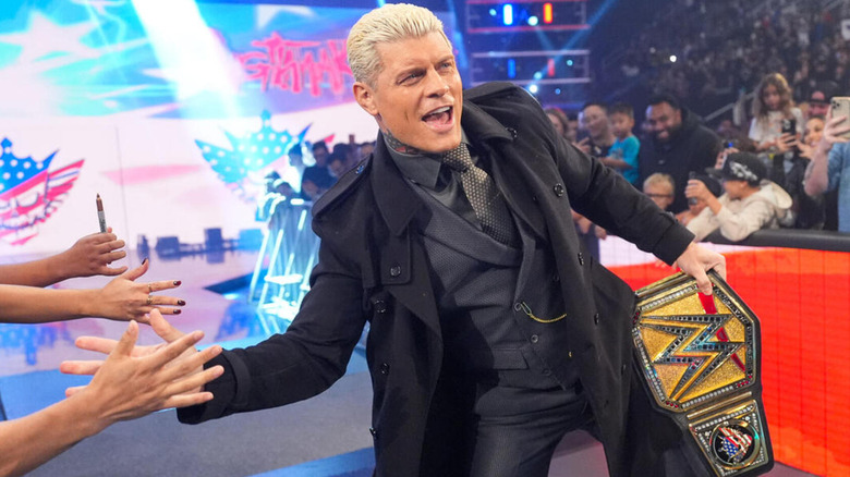 Cody Rhodes smiles as he gives the crowd their high-fives during his entrance as the WWE Universal Champion.