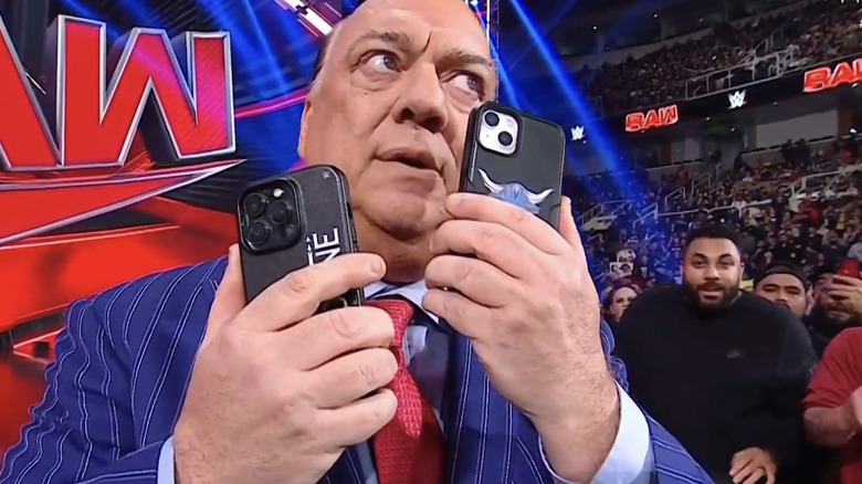 Paul Heyman holds two phones