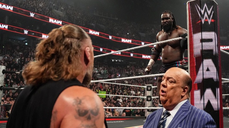Oba Femi stares down Brock Lesnar from the ring, as Paul Heyman tries to calm Lesnar down, during an episode of 