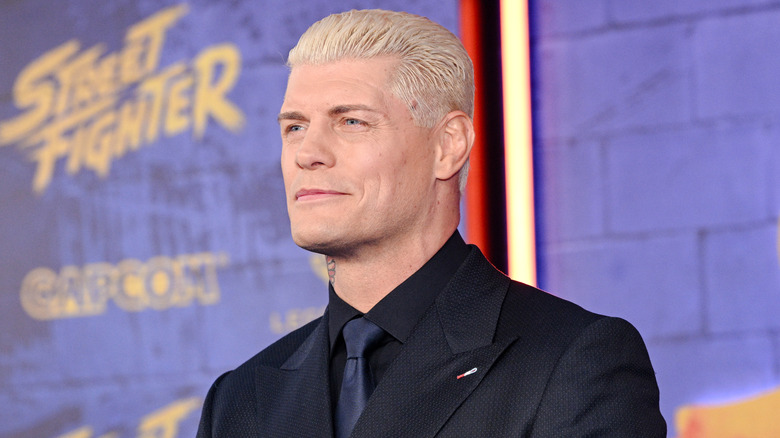 Cody Rhodes wearing a suit and smiling
