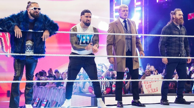 Seth Rollins, Cody Rhodes, Sami Zayn, and Jey Uso stand outside of the ring, challenging The Judgment Day and Drew McIntyre.