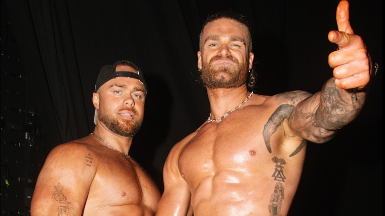 Colten Gunn gives the "guns up" gesture in a backstage photo with his brother Austin posing beside him