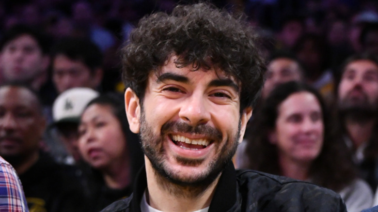 Tony Khan attending a sporting event and smiling