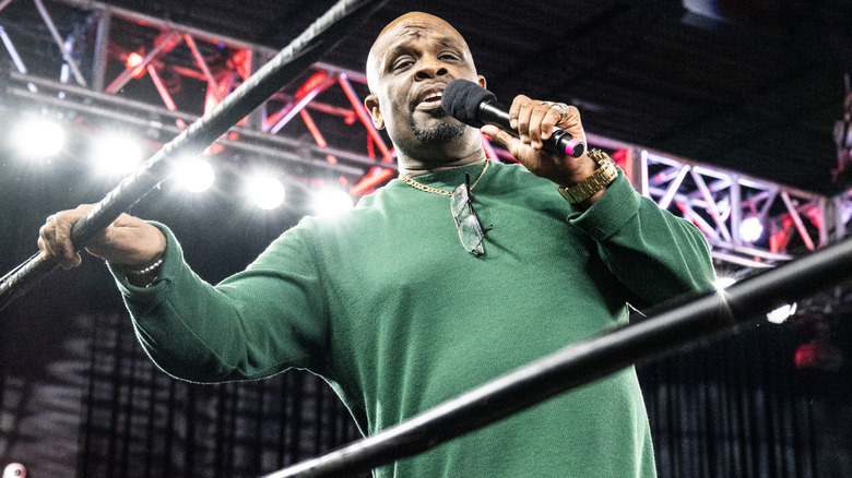 D-Von Dudley speaking into a mic and holding onto a ring rope