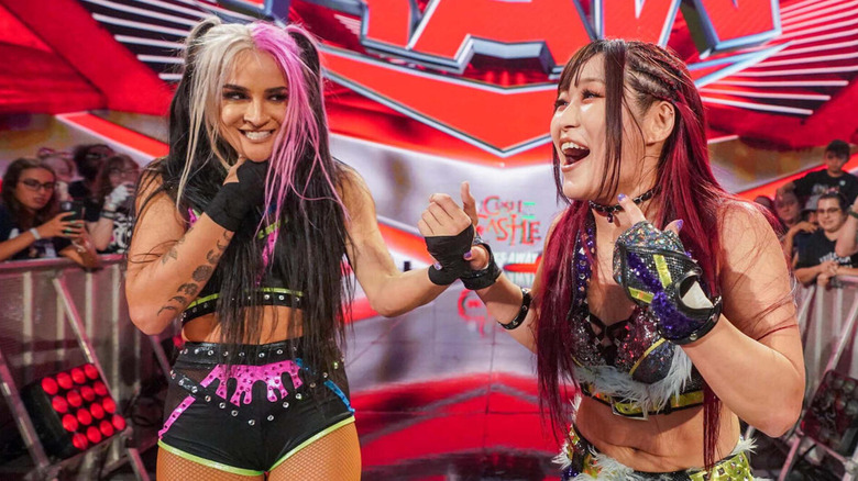 Dakota Kai grins menacingly beside IYO SKY