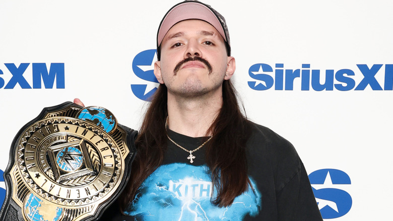 Dominik Mysterio holding the WWE Intercontinental championship