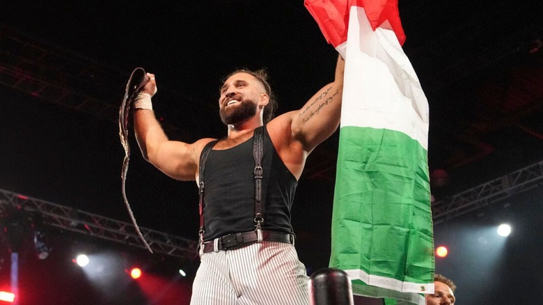 Tony D'Angelo stands on the ropes holding the NXT North American Championship and an Italian flag after winning the title on "WWE NXT."