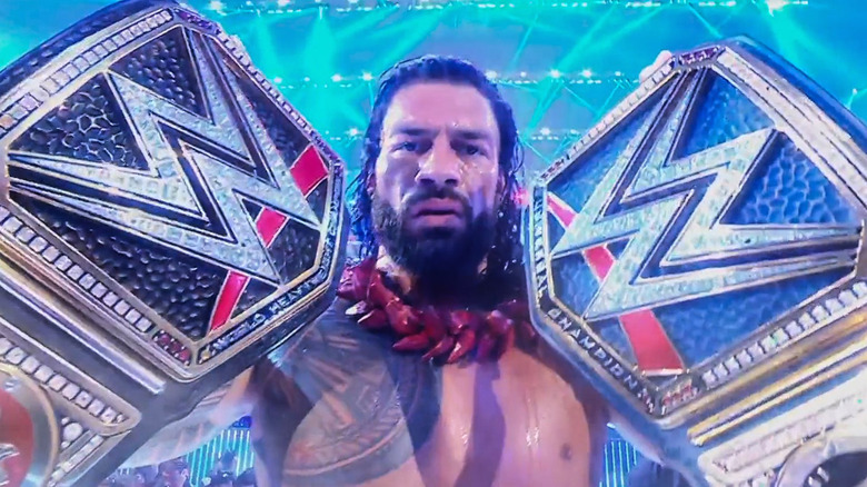 Roman Reigns, holding the belts he'll never lose