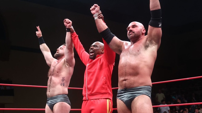 Stokely Hathaway hold up FTR's arms following a victory.