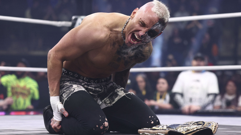 Darby Allin kneels in the ring in front of the AEW World Championship after winning the belt from MJF on an episode of 