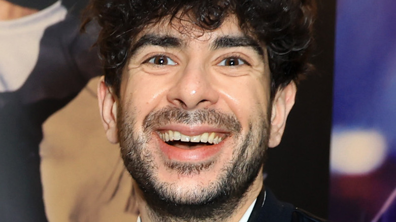 Tony Khan at an event, shaking a hand