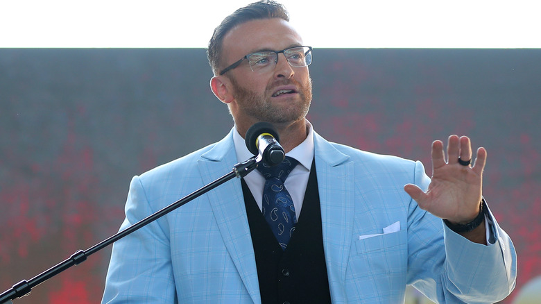 Nick Aldis wearing a blue suit