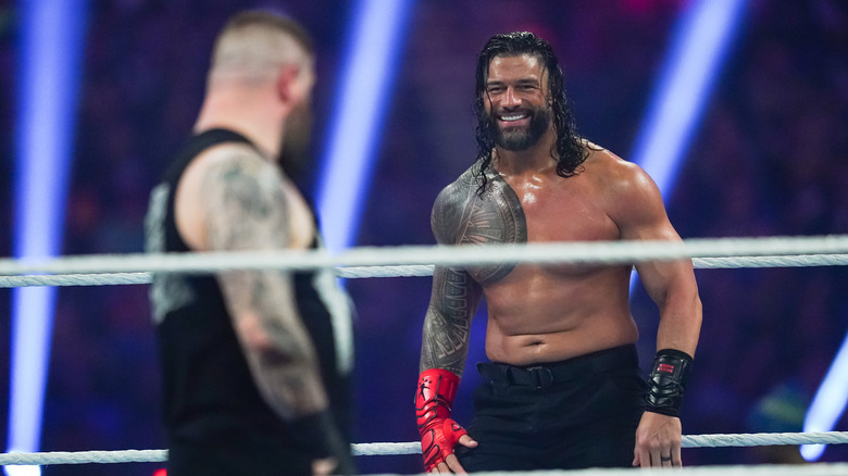 Roman Reigns smiles at Kevin Owens