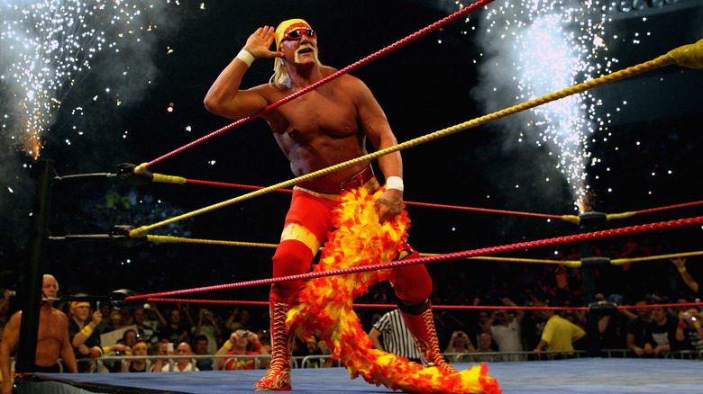 Hulk Hogan poses with his hands up against his ear doing what he was known to do best: ignite an electric response from the crowd