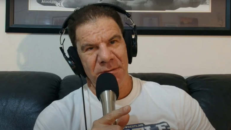 Dave Meltzer holds mic