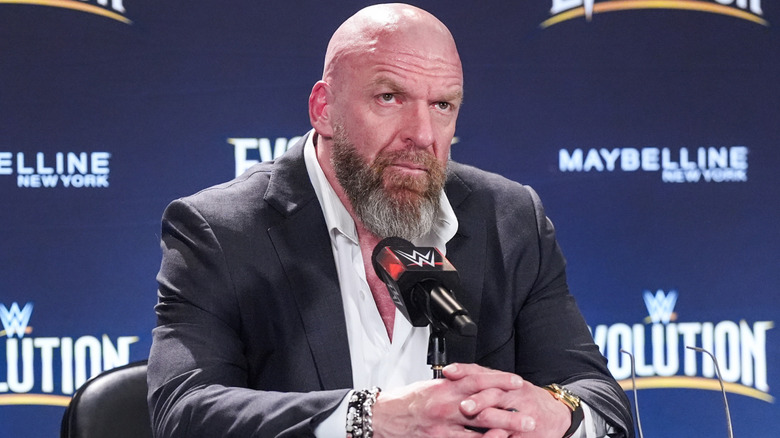 Triple H sitting in front of a microphone
