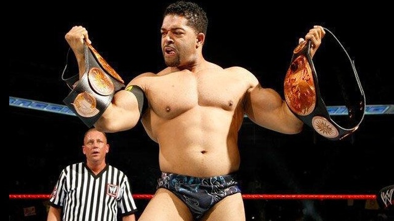 David Otunga looks at his newly won WWE Tag Team Championships