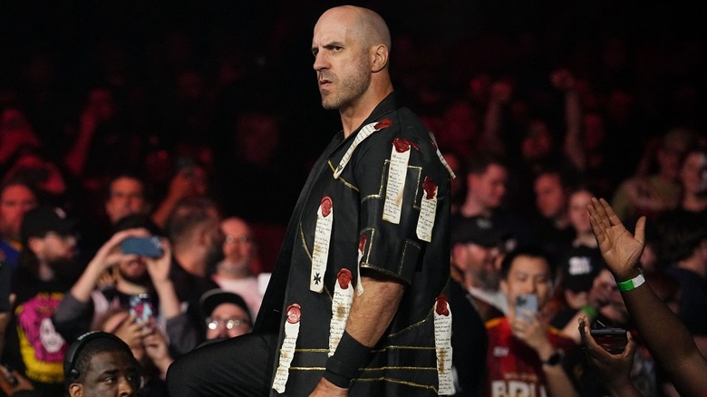 Claudio Castagnoli approaches the ring with a series expression and a short-sleeved jacket with several scarlet wax stamps and notes.