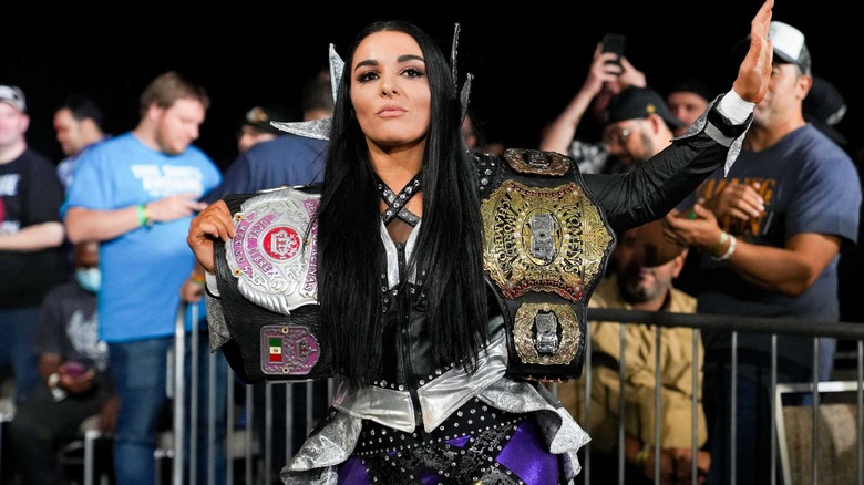 Deonna Purrazzo carrying two title belts