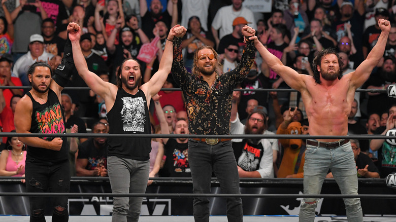 The Elite raising their hands in an AEW ring