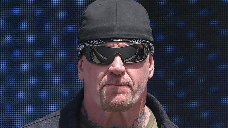 Undertaker with his hat on backwards and wearing sunglasses