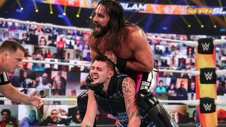 Seth Rollins puts Dominik Mysterio in a hold in the middle of the ring during a match in WWE's 