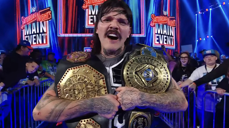 Dominik Mysterio shouts as he holds both the AAA Mega Championship and the WWE Intercontinental Championship on the entrance ramp of 