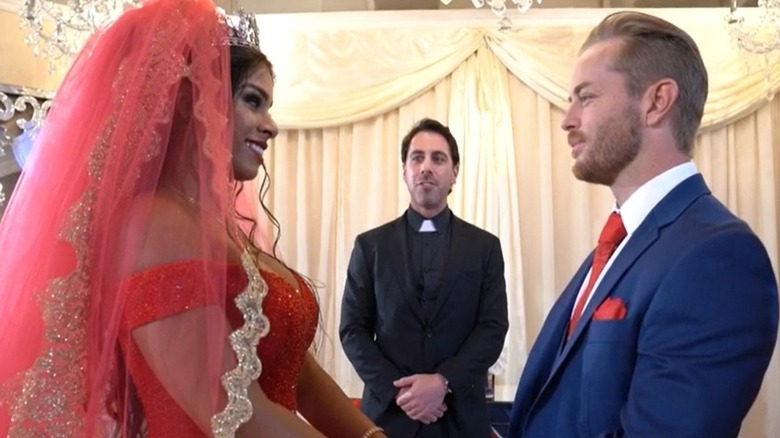 Drake Maverick stands across from his wife, as the officiant looks on, during his real wedding, filmed by WWE in 2019.