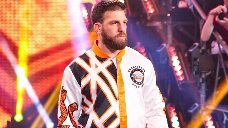 Drew Gulak wearing a white and orange jacket