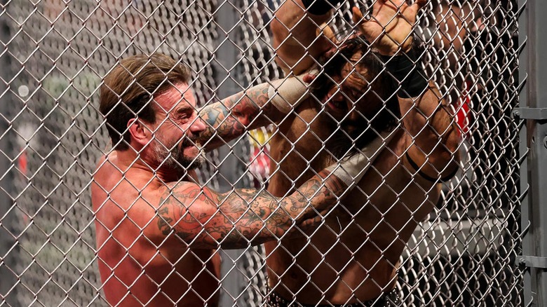 CM Punk and Drew McIntyre clashing during their October 2024 Hell in a Cell match at WWE Bad Blood.