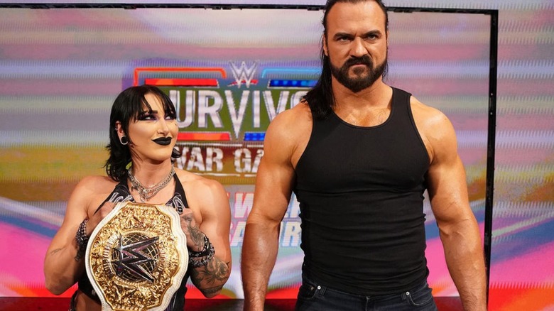 Rhea Ripley smirks up at Drew McIntyre on the stage