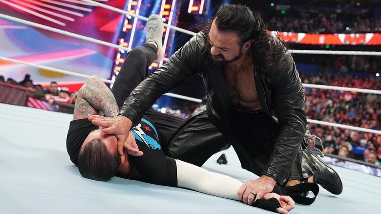 Drew McIntyre pinning CM Punk down after attacking him during a "RAW" match.