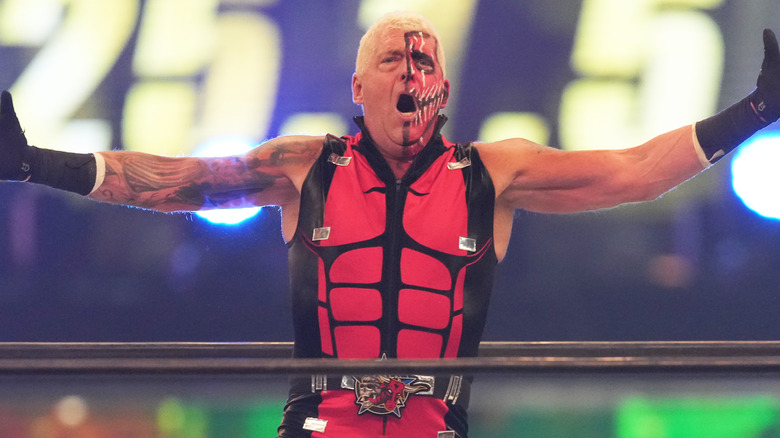 Dustin Rhodes yells with his arms outstretched.