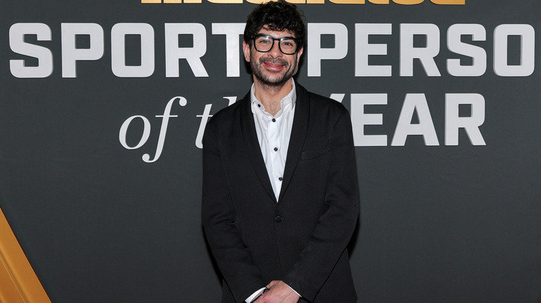 Tony Khan in front of a banner that reads Sports Illustrated Sportsperson of the Year
