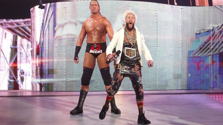 Enzo Amore, microphone in hand, stands with Big Cass on the stage before a match in WWE.