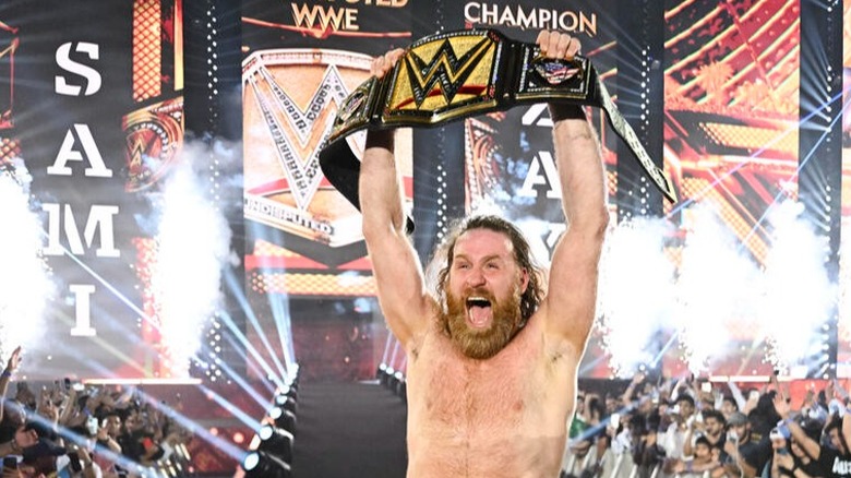Still shocked seconds after pulling off the biggest win in his career, Sami Zayn holds up his newly won Undisputed WWE Championship at Night of Champions