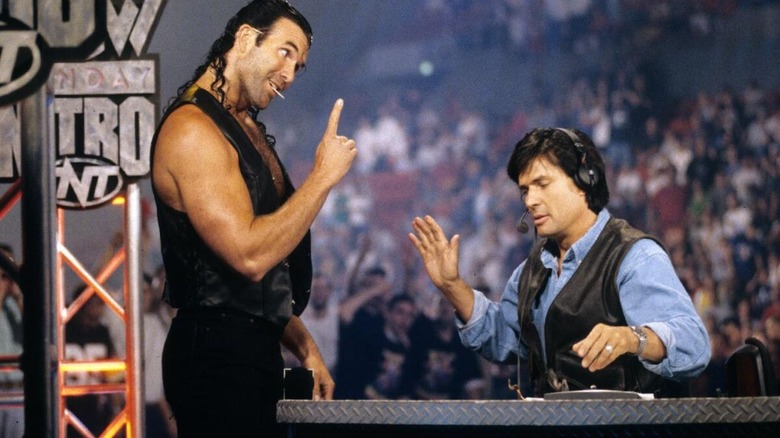 Scott Hall motions to Eric Bischoff, who sits on commentary, during a segment on an episode of "WCW Monday Nitro."
