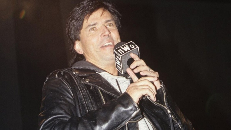 Eric Bischoff cuts a promo, nWo branded microphone in hand, during an episode of WCW programming, in a photo posted to WWE's website.