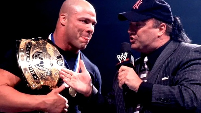 Paul Heyman gestures to Kurt Angle