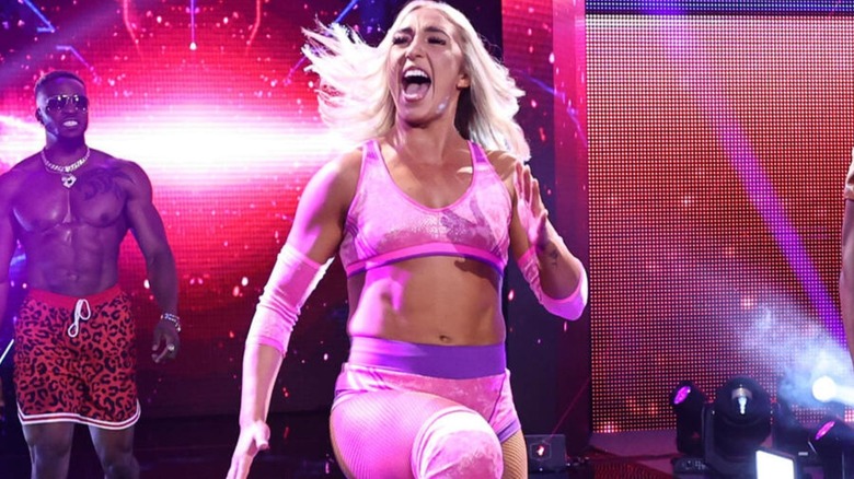 Brinley Reece skips out to the ring for a match on "WWE NXT," flanked by Edris Enofe.