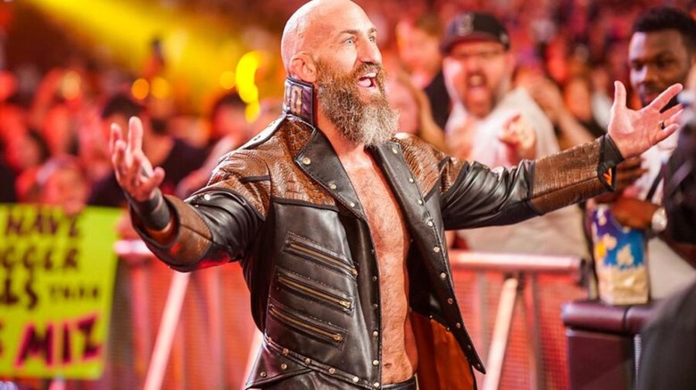 Tommaso Ciampa gestures wide as he heads down the ramp to the ring for a match on WWE programming.