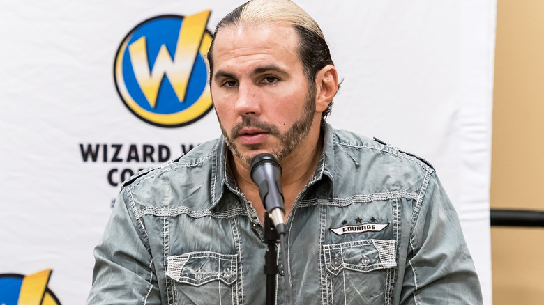 Matt Hardy is sitting in front of a microphone