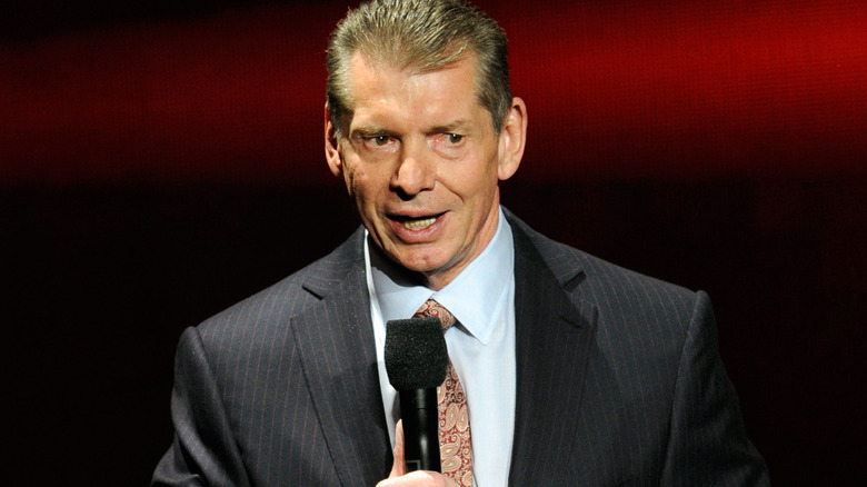 Vince McMahon is holding a microphone