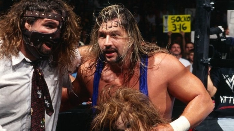 Mankind with Al Snow during a ringside segment in WWE.