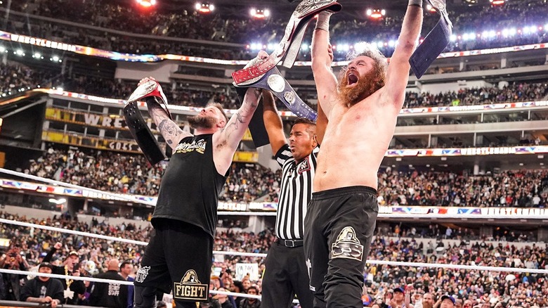 Kevin Owens and Sami Zayn celebrating at WWE WrestleMania 39 with the PWG logo visible