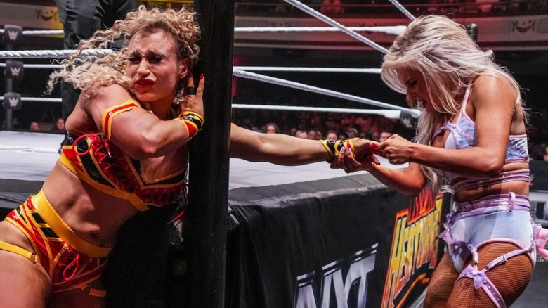 Blake Monroe works the fingers of Jordynne Grace around the ring post during their match at 