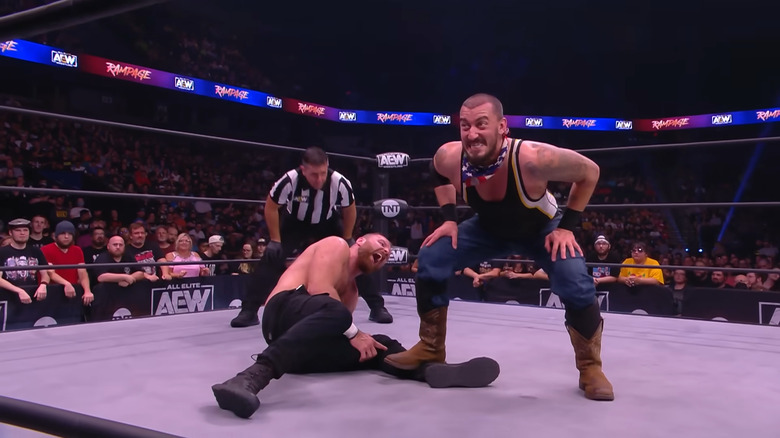 Mance Warner standing on Jon Moxley's leg